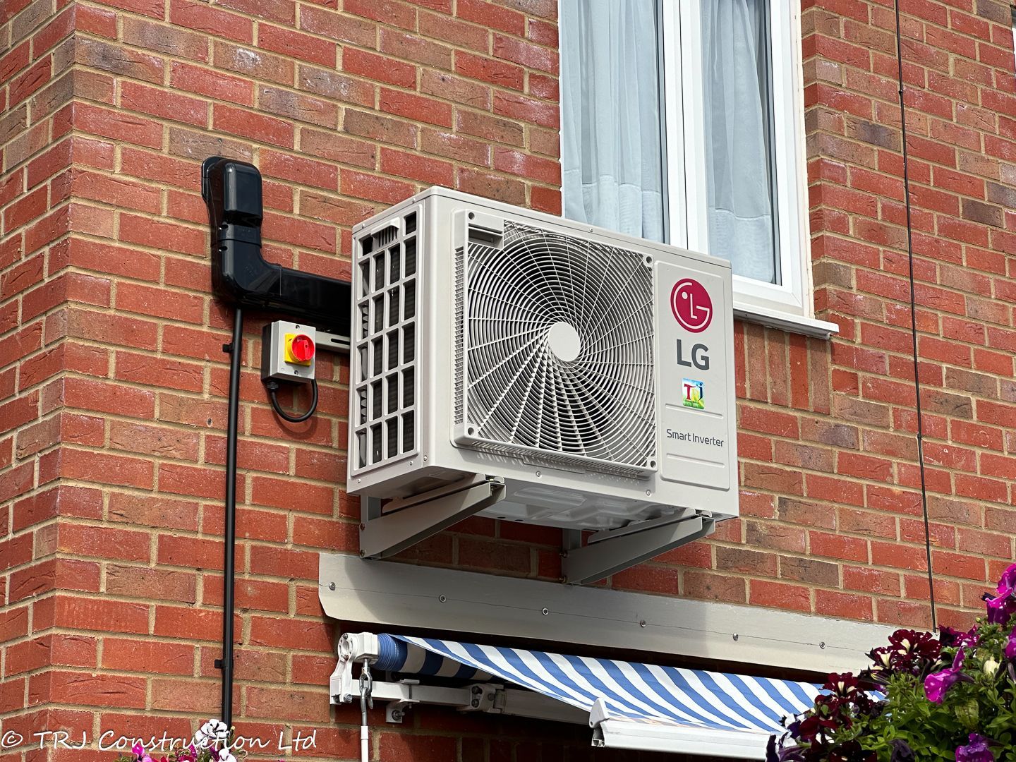 Outdoor LG air-conditioning unit mounted on a brick wall