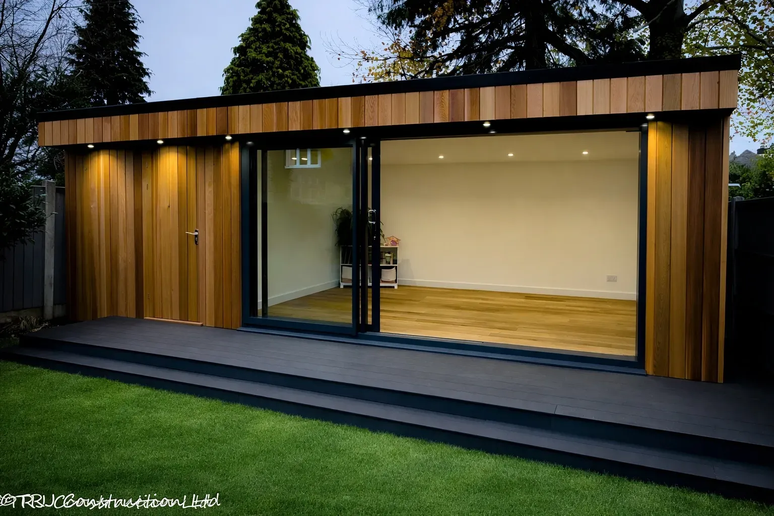 Cedar-clad garden room with glazed doors, decking and lawn in Brentwood